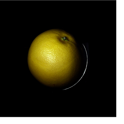 A yellow grapefruit is shown against a dark background with a highlight on the right edge.